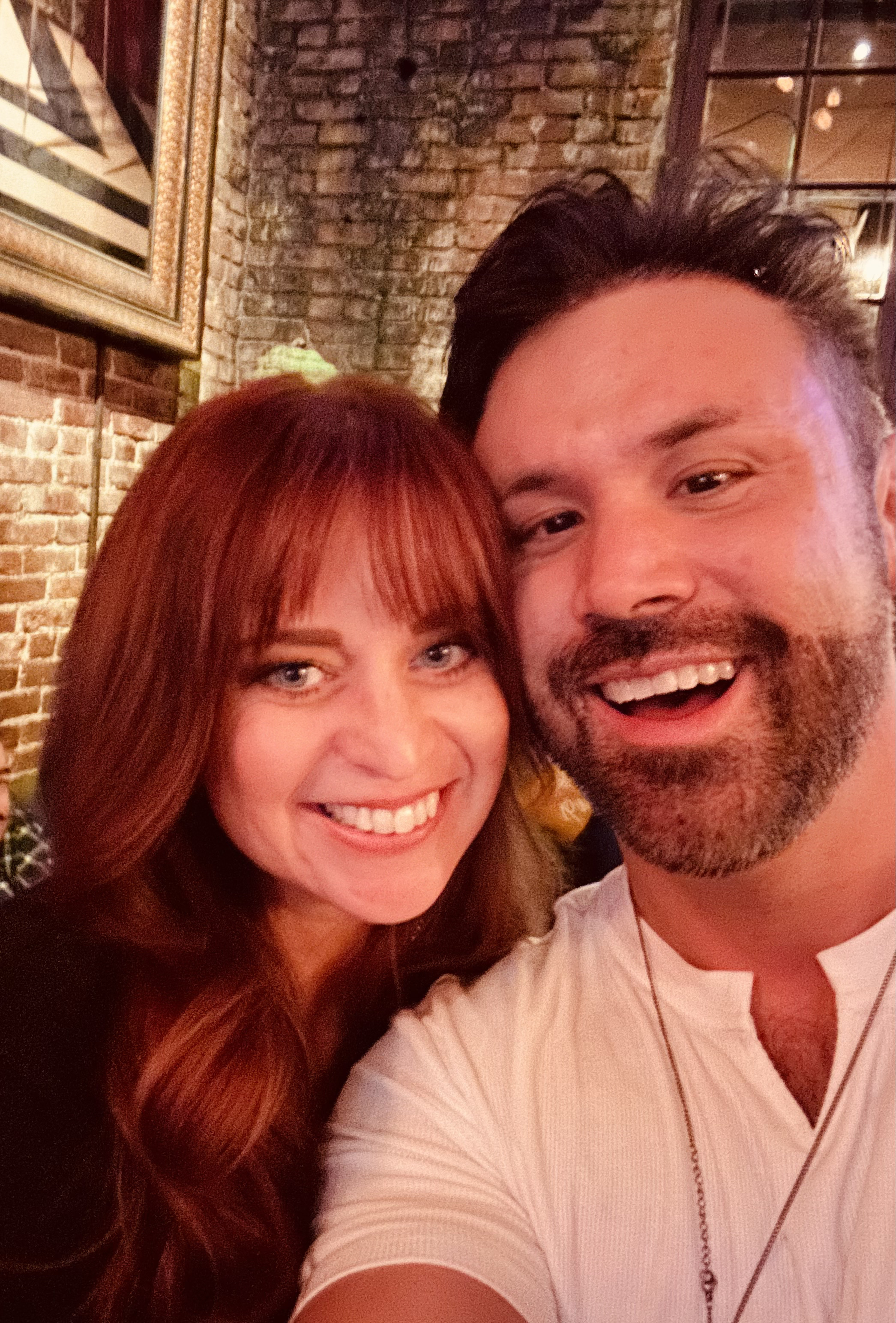Laughing together at a brick-walled bar